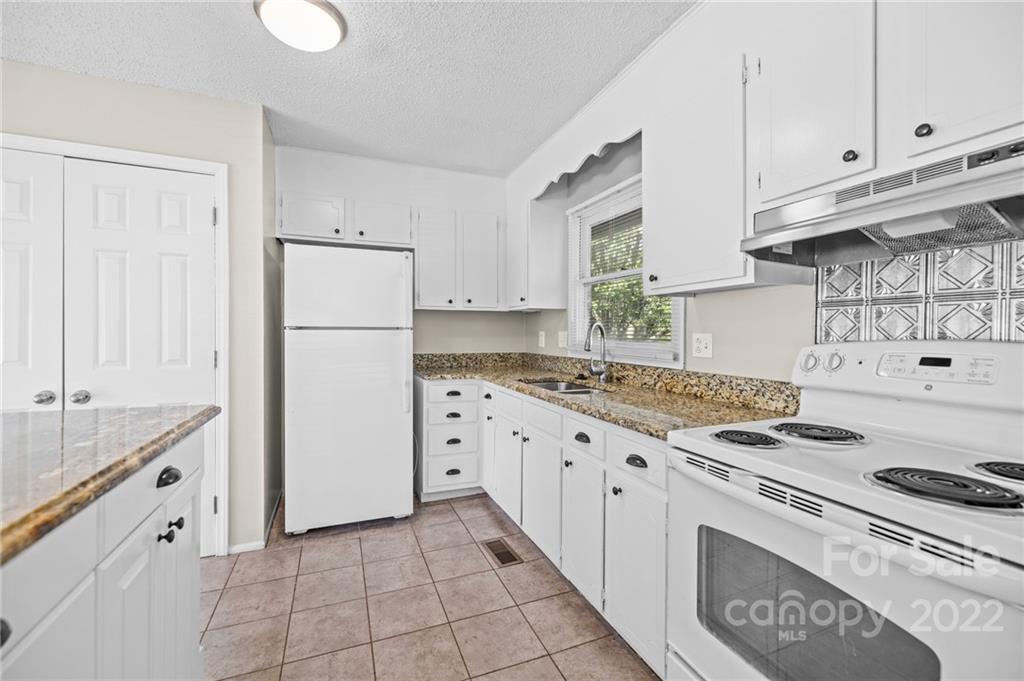 2328 Weddington Road Charlotte, NC 28270 - Photo 13 of 24 a kitchen with granite countertop a sink stove and refrigerator