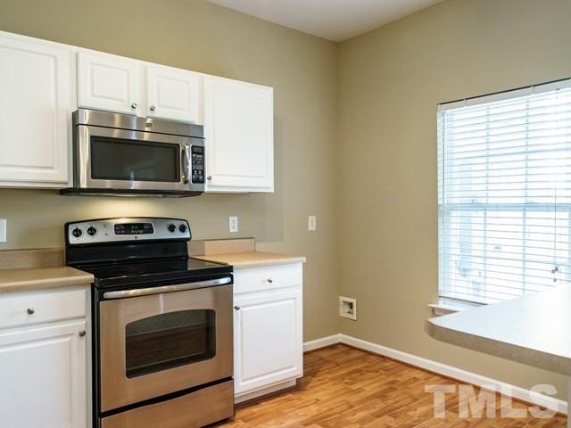 4213 Vienna Crest Drive Raleigh, NC 27613 - Photo 12 of 24 a kitchen with a stove and a microwave