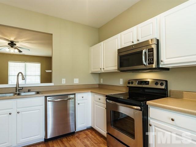 4213 Vienna Crest Drive Raleigh, NC 27613 - Photo 13 of 24 a kitchen with stainless steel appliances granite countertop grey cabinets a stove a sink and dishwasher