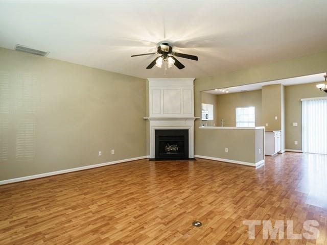 4213 Vienna Crest Drive Raleigh, NC 27613 - Photo 6 of 24 a view of a livingroom with a fireplace a ceiling fan and wooden floor