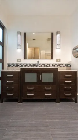 a bathroom with a granite countertop toilet a sink and a mirror