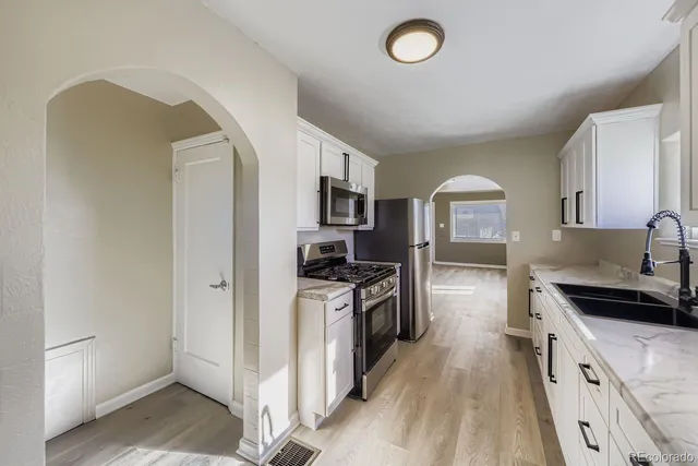 a kitchen with stainless steel appliances granite countertop a stove a sink and a refrigerator