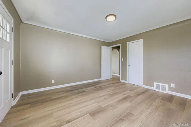 a view of empty room with wooden floor