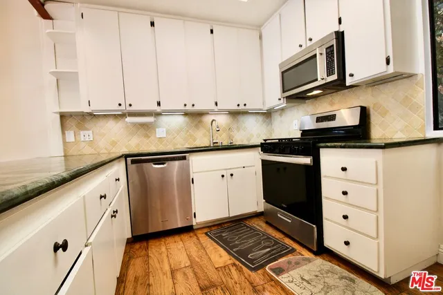 a kitchen with stainless steel appliances granite countertop a sink and cabinets