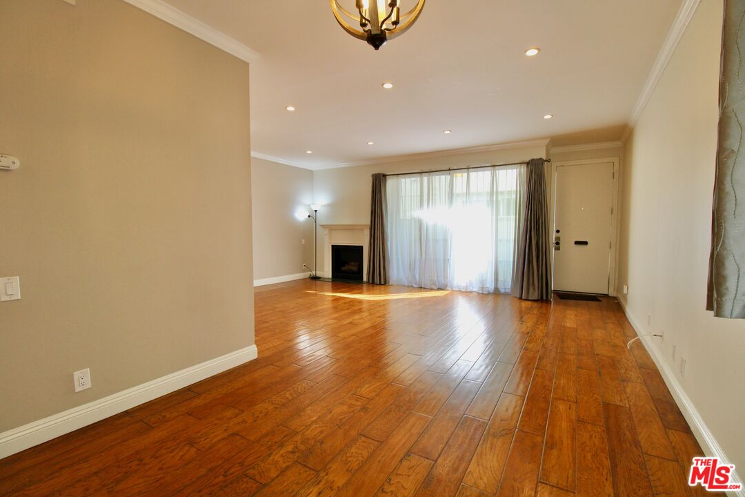 1825 Thayer Avenue Los Angeles, CA 90025 - Photo 5 of 38 a view of an empty room with wooden floor and a window