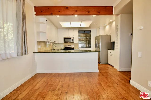 a kitchen with stainless steel appliances a refrigerator and a stove top oven
