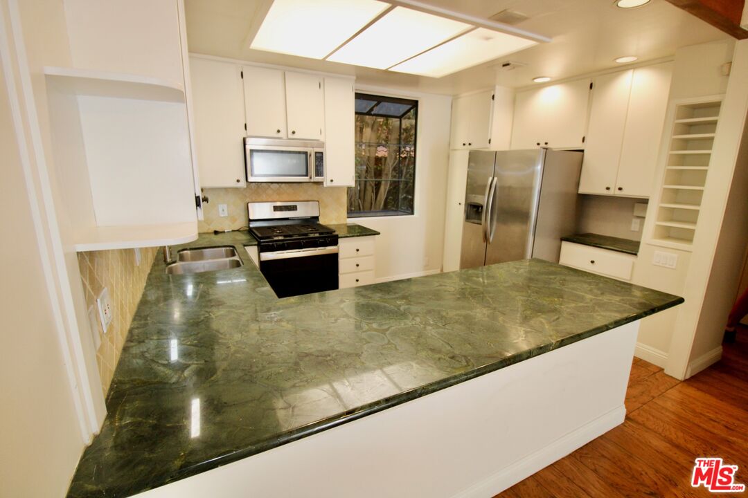 1825 Thayer Avenue Los Angeles, CA 90025 - Photo 10 of 38 a kitchen with stainless steel appliances granite countertop a refrigerator a stove and a sink