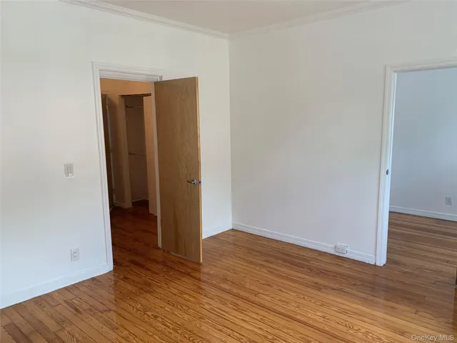 an empty room with wooden floor and closet