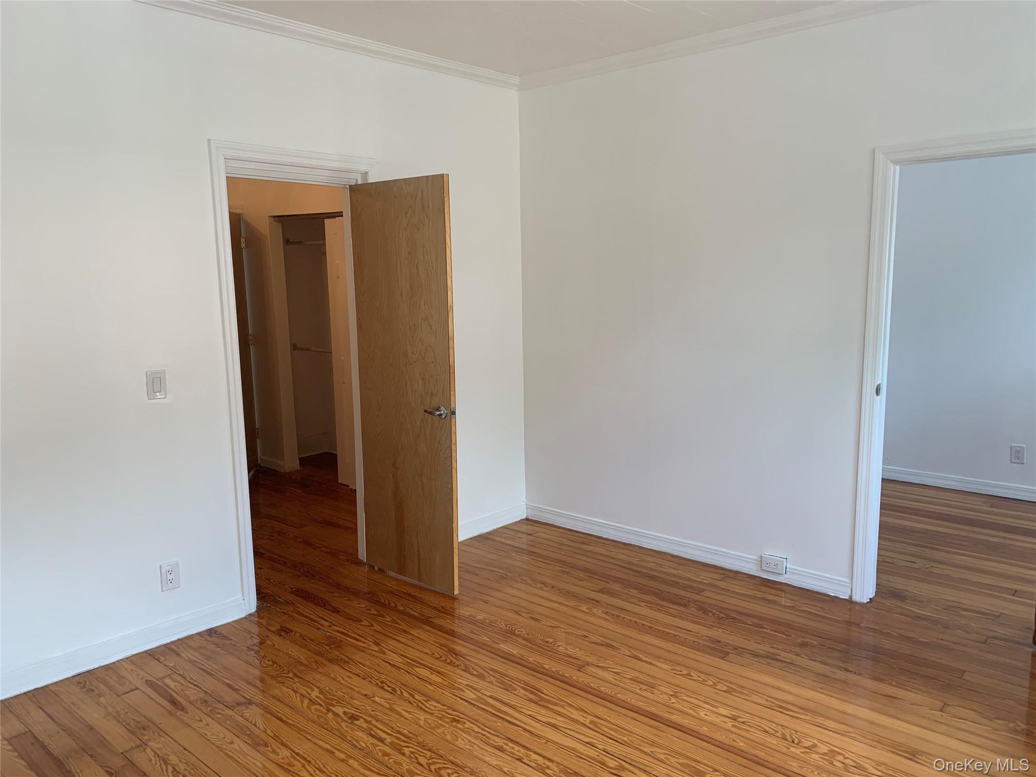 60-24 56th Road, Unit 2 Queens, NY 11378 - Photo 11 of 14 an empty room with wooden floor and closet