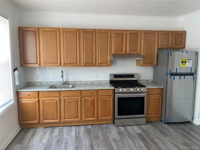 a kitchen with granite countertop wooden cabinets and a stove top oven