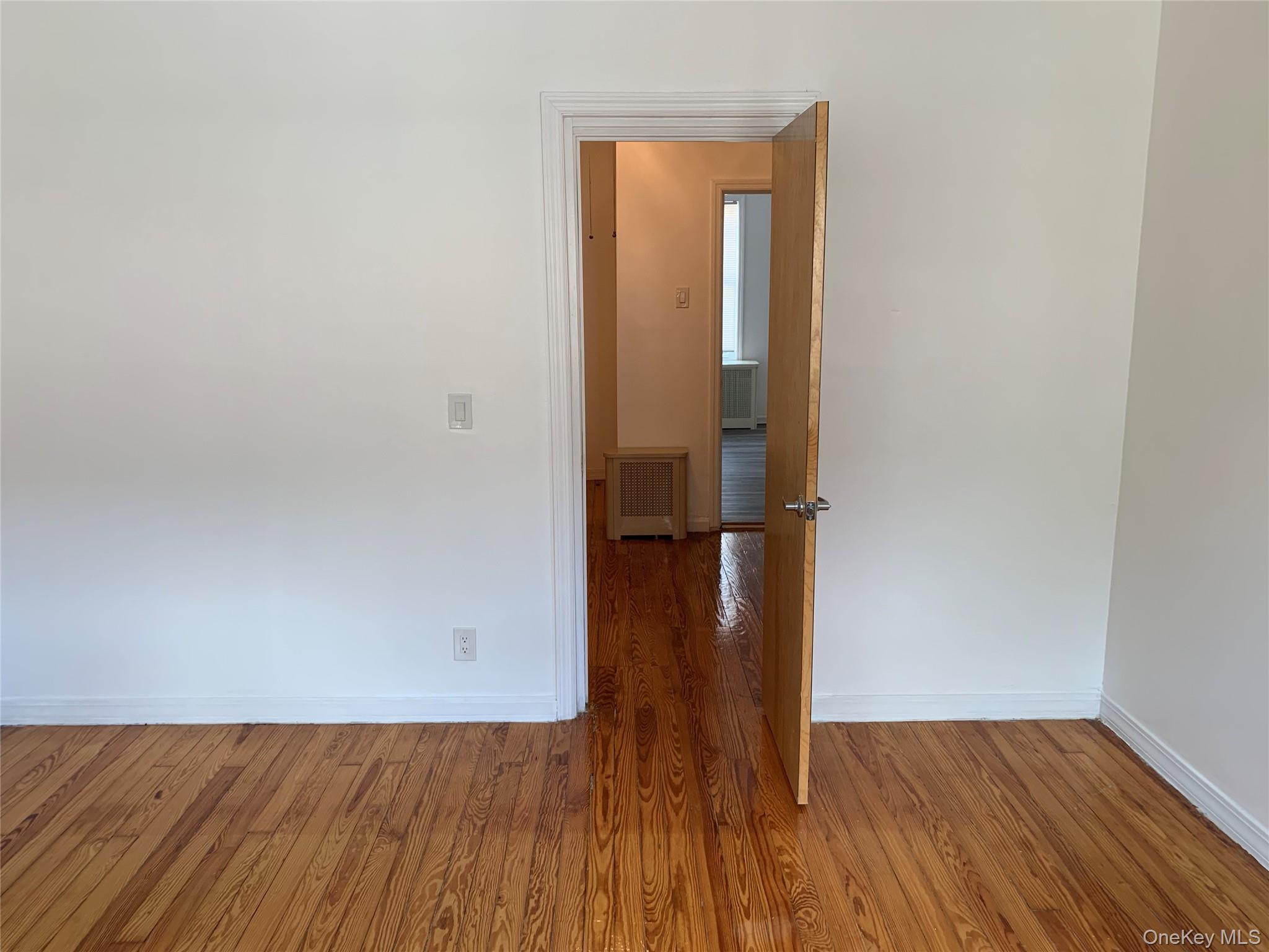 60-24 56th Road, Unit 2 Queens, NY 11378 - Photo 10 of 14 a view of empty room with wooden floor