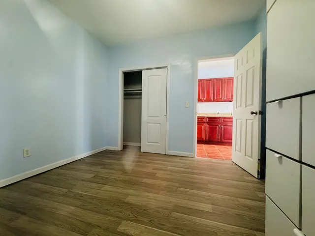 a view of empty room with wooden floor