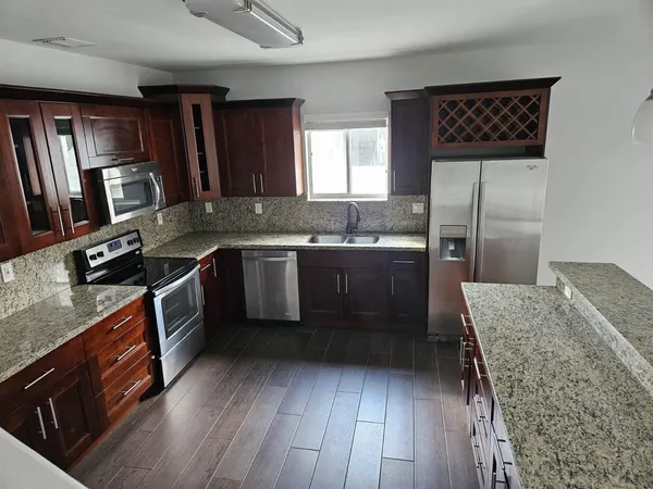 a kitchen with granite countertop a sink stove and refrigerator