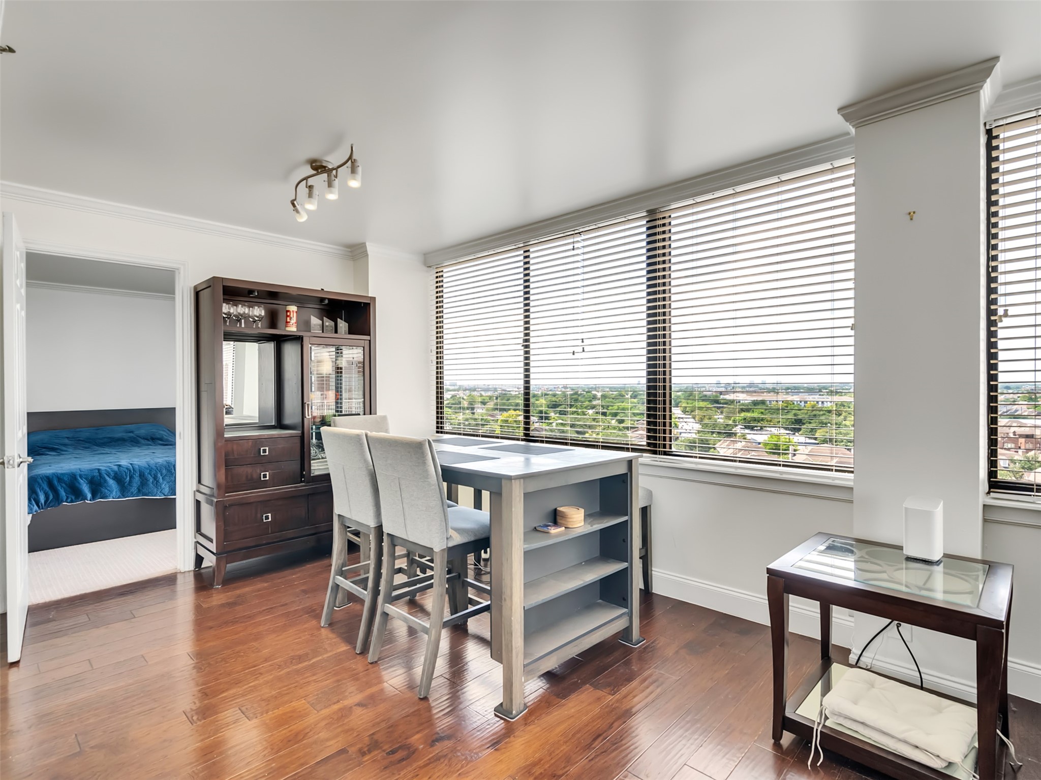 3525 Sage Road, Unit 1210 Houston, TX 77056 - Photo 7 of 20 Bright dining area with expansive windows offering panoramic views, featuring hardwood floors and modern furnishings. Adjacent to a cozy bedroom.