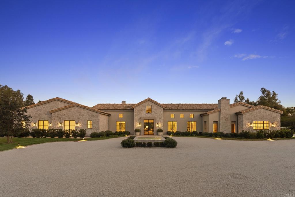 17845 Via De Fortuna Rancho Santa Fe, CA 92067 - Photo 19 of 20 a front view of a house with a garden and a car parked in it