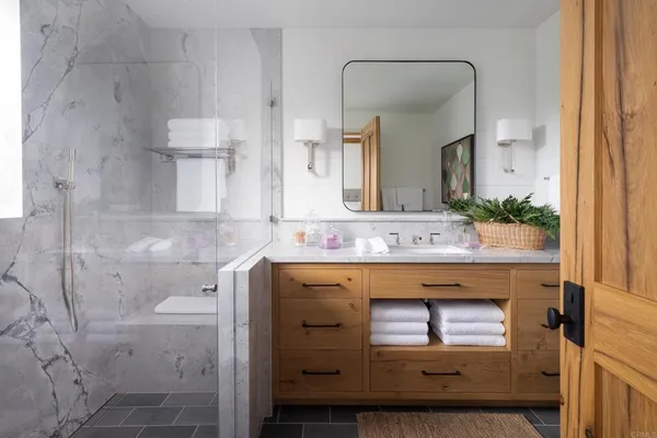 a view of a patio with table and chairs potted plants and floor to ceiling window