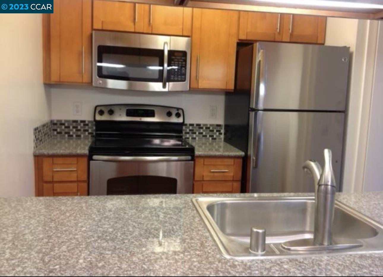 a kitchen with stainless steel appliances granite countertop a stove a refrigerator and a sink