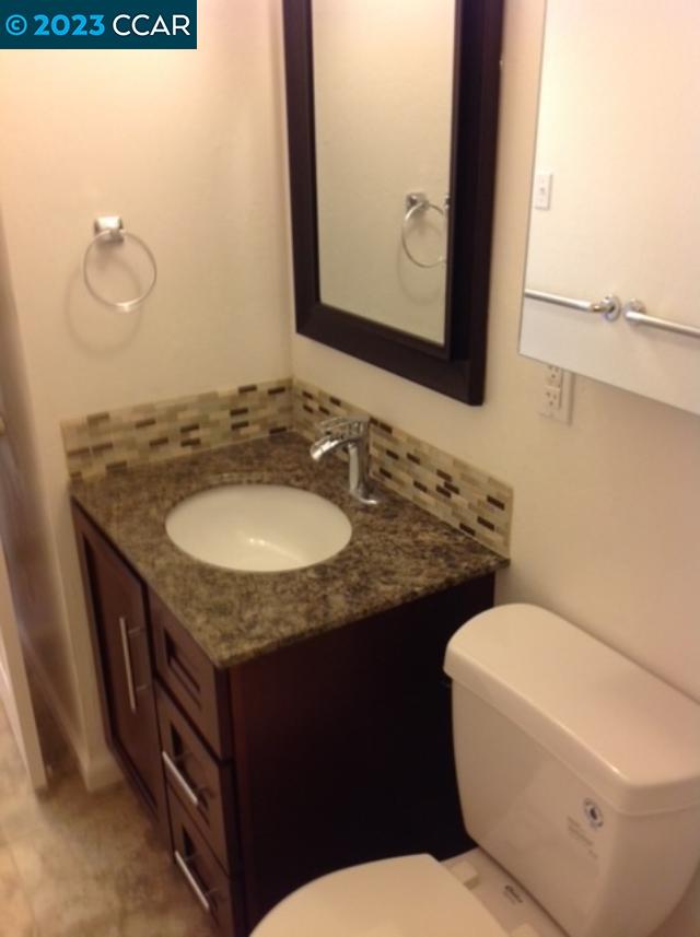 2019 Olivera Road, Unit B Concord, CA 94520 - Photo 3 of 7 a bathroom with a granite countertop toilet sink and mirror