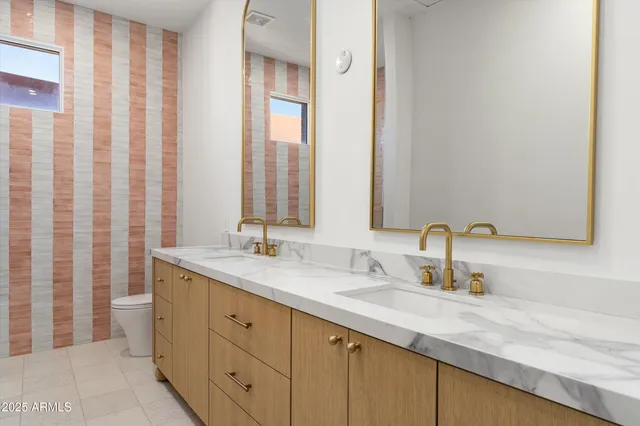 a bathroom with double sink and a mirror