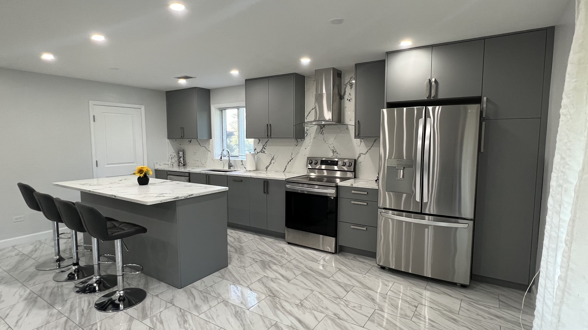 121 Windsor Lane, Unit D Willowbrook, IL 60527 - Photo 5 of 23 a kitchen with stainless steel appliances kitchen island granite countertop a refrigerator and a sink