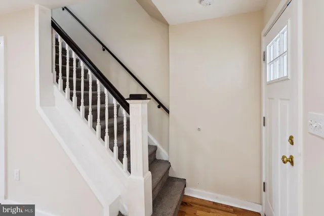 a view of a hallway with wooden floor and entryway