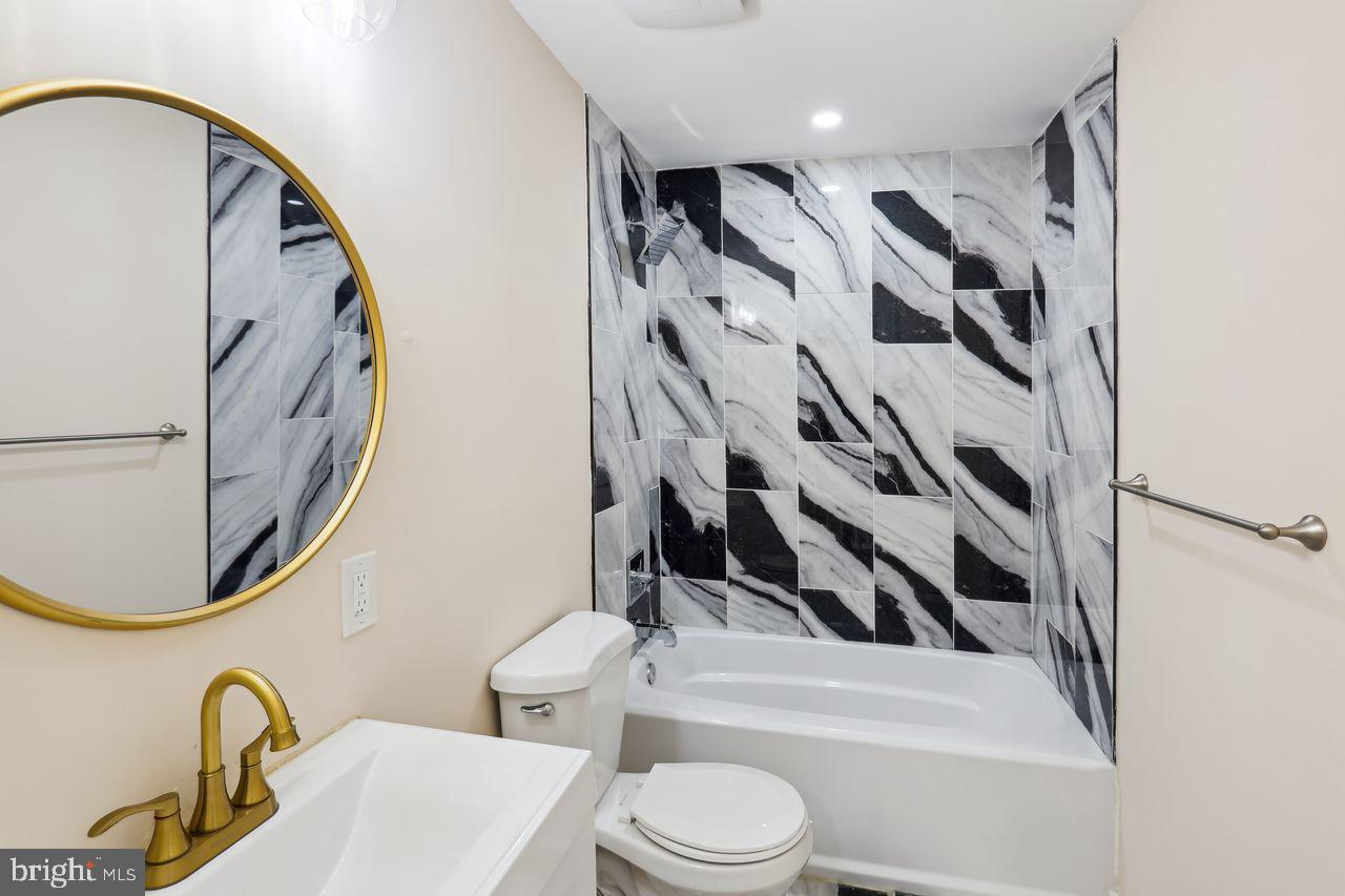 3701 Manchester Avenue Baltimore, MD 21215 - Photo 18 of 34 a bathroom with a toilet a sink and a mirror