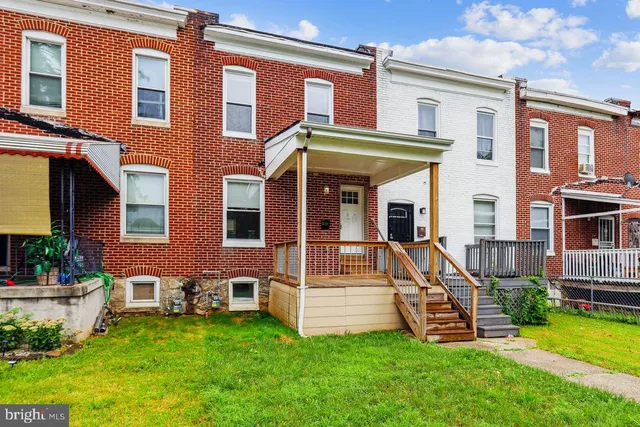 a view of a house with a yard and a large tree