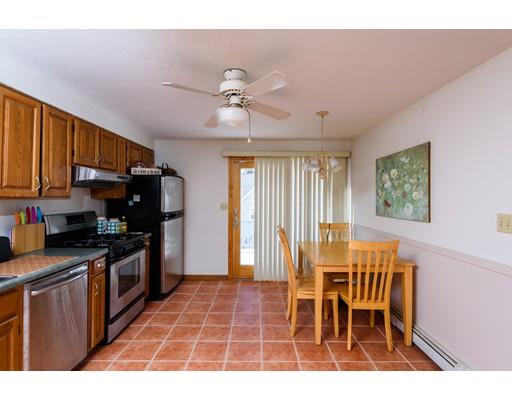 101 Olympia Road Marshfield, MA 02050 - Photo 8 of 24 a kitchen with stainless steel appliances granite countertop a stove top oven a refrigerator a sink dishwasher with a dining table and chairs
