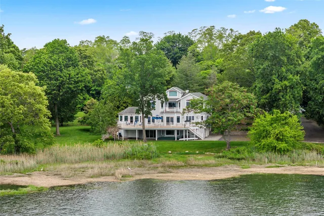a view of a house with a big yard and large trees