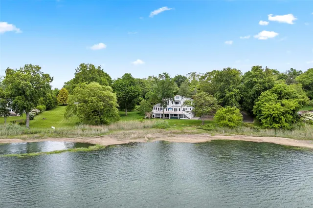 an aerial view of a residential houses with outdoor space and lake view