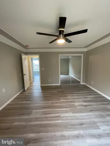 a view of empty room with wooden floor