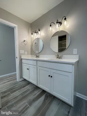 a spacious bathroom with double sink and a mirror