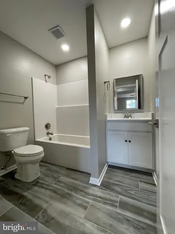a bathroom with a toilet sink a mirror and a bathtub