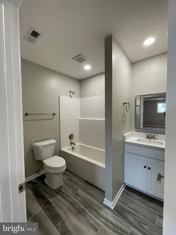 a bathroom with a toilet sink a mirror and shower