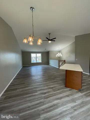 a view of a room with wooden floor and a ceiling fan