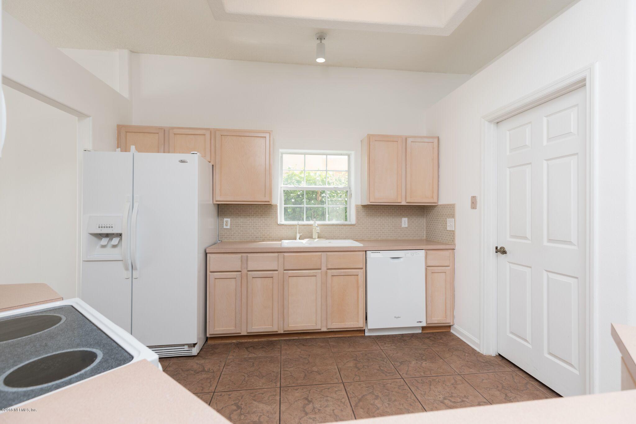 128 Cedar Ridge Circle St. Augustine, FL 32080 - Photo 20 of 37 a kitchen with a refrigerator a stove top oven and cabinets