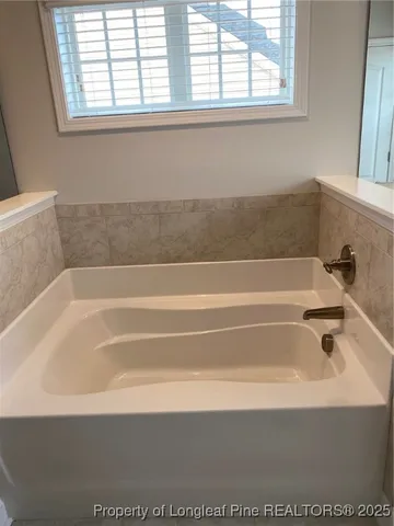 a bathroom with bathtub and window
