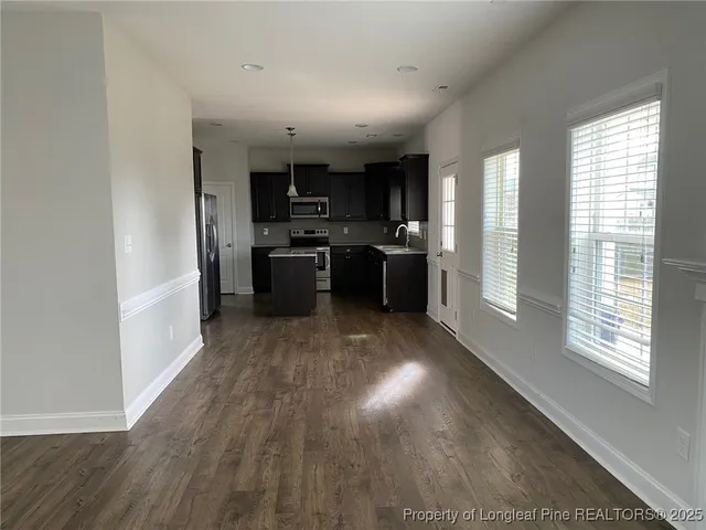a large white kitchen with wooden floor