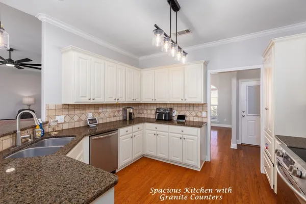 a kitchen with stainless steel appliances granite countertop a sink a stove and refrigerator