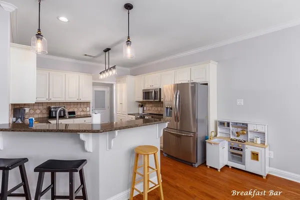 a kitchen with kitchen island a refrigerator stove and microwave