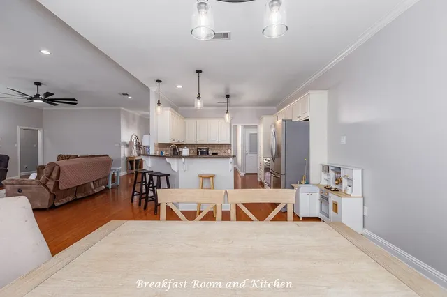 a living room with stainless steel appliances kitchen island granite countertop furniture a rug kitchen view and a chandelier