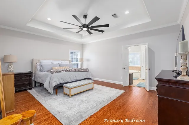 a spacious bedroom with a bed and dresser