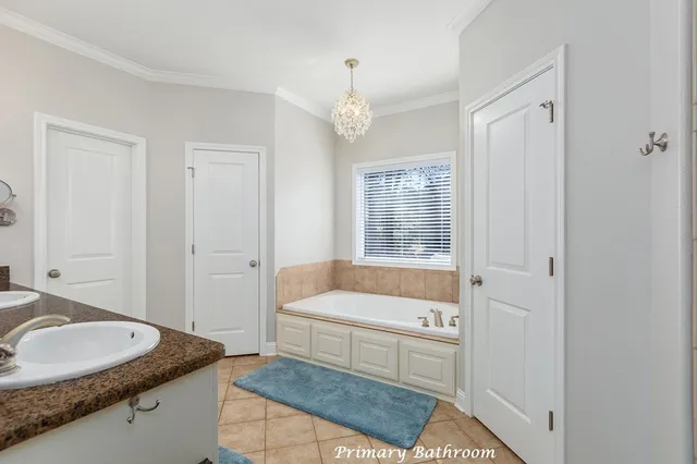 a bathroom with a granite countertop tub a sink and a window