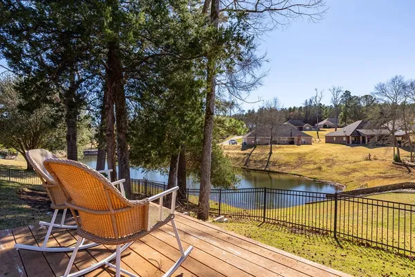 a view of a terrace with chairs and wooden fence