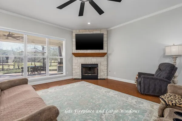 a living room with furniture a flat screen tv and a fireplace