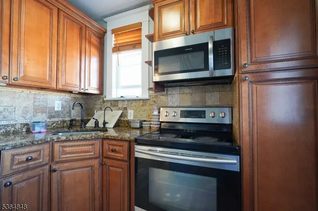a kitchen with stainless steel appliances granite countertop a stove microwave and sink