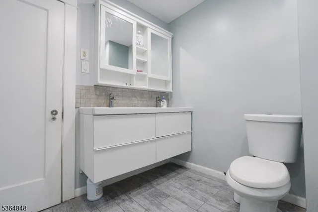 a bathroom with a sink toilet and mirror