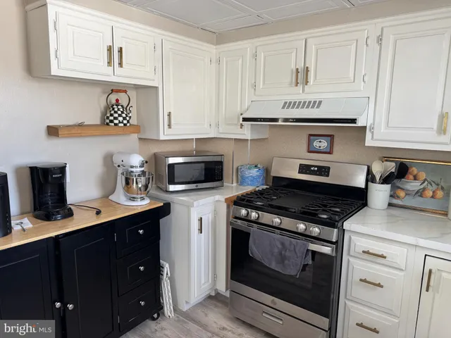 a kitchen with stainless steel appliances a stove a sink a refrigerator and cabinets