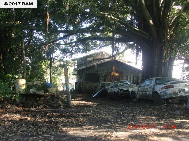 a view of a house with a yard fire pit and tree