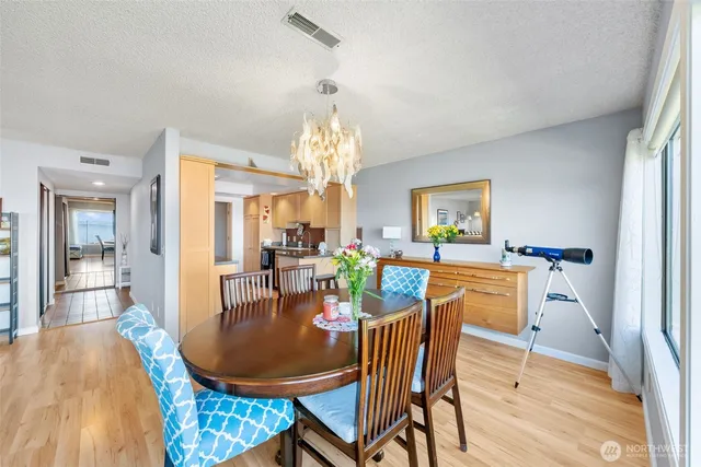 a dining room with furniture a chandelier and wooden floor